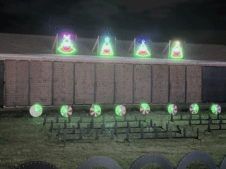 A gif of a screen of lights flashing an image of Santa's sleigh flying through the air