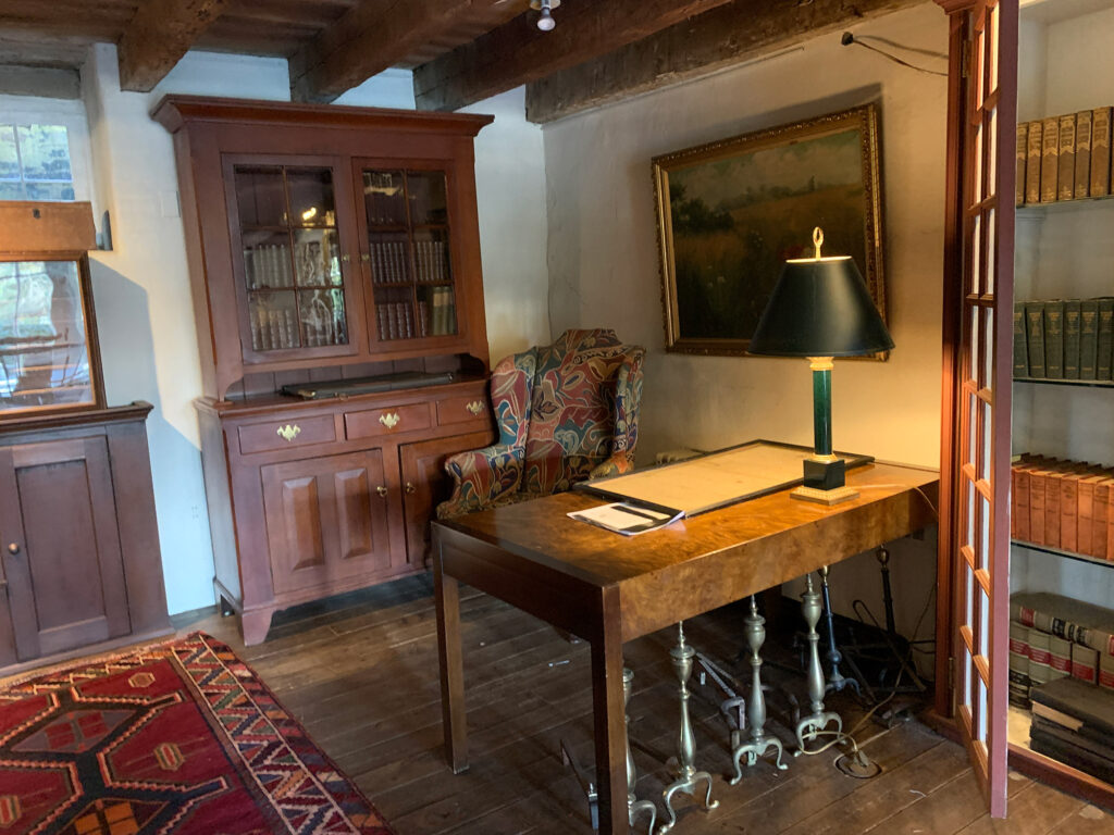 Antique desk in front of an old cabinet filled with historic books