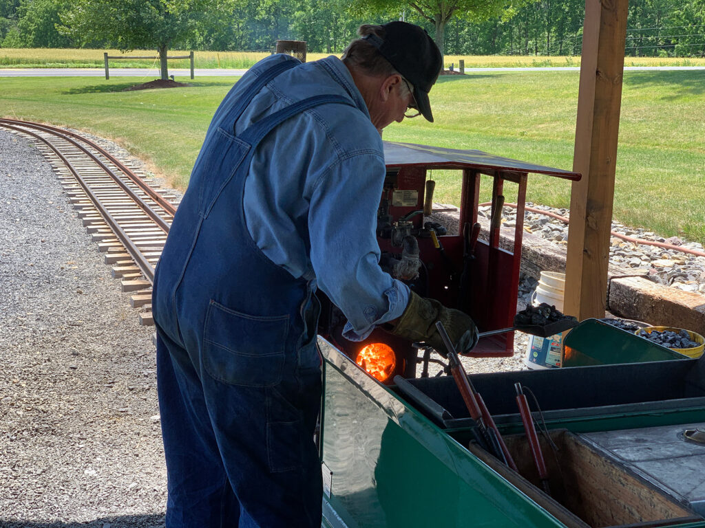 Engineer firing up a miniature train at Bear Rock Junction
