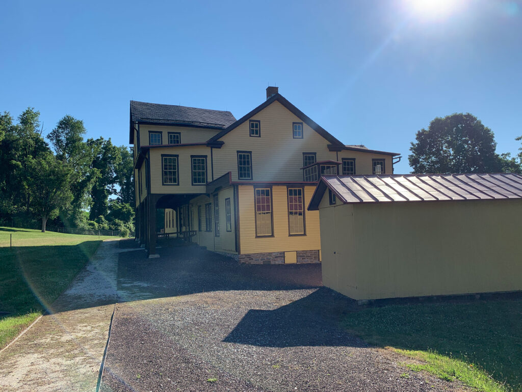 large wooden building painted yellow with brown trim