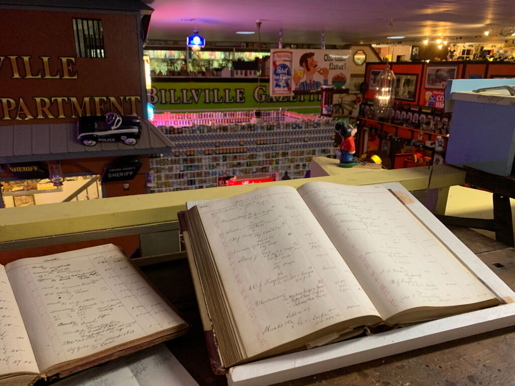 a ledger book poised on a railing overlooking multiple displays inside Bill's Old Bike Barn