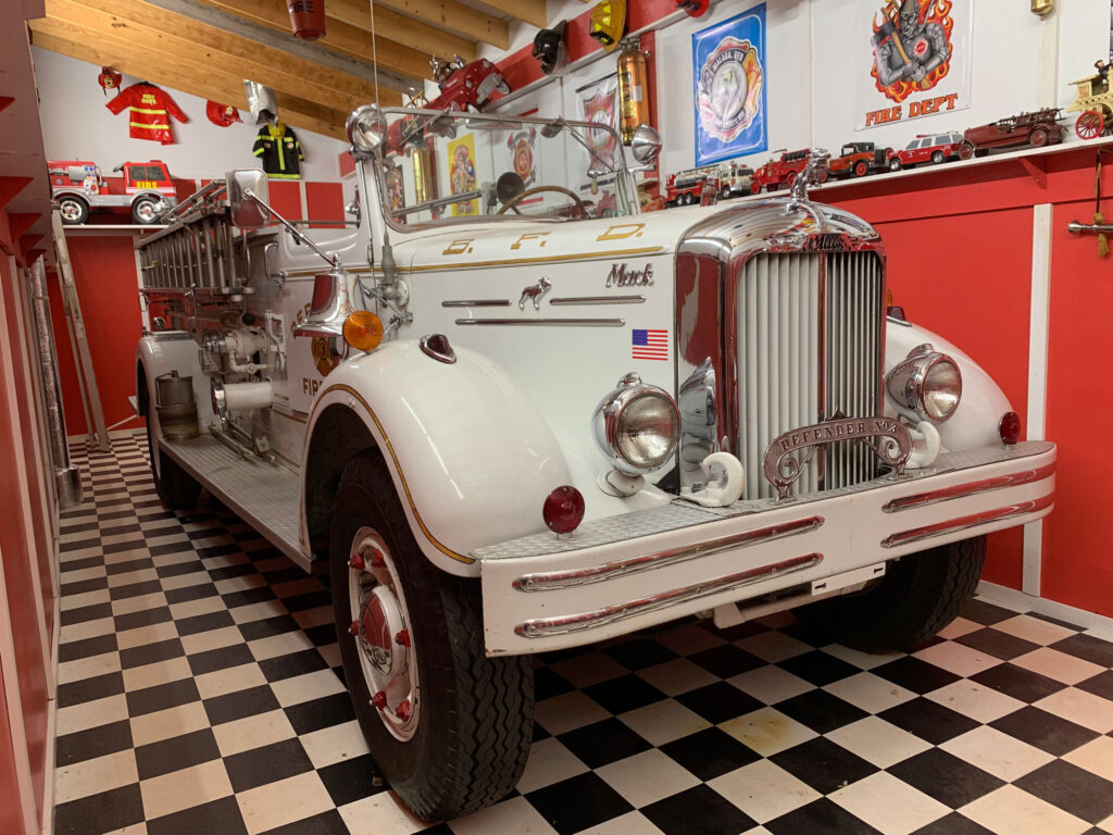 A white antique fire truck inside a recreated fire station at Bill's Old Bike Barn