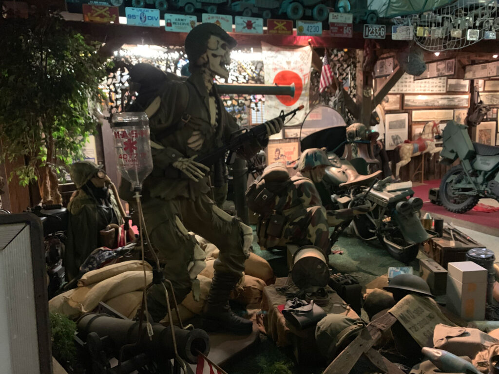 Military equipment display including a bike, Jeep and figures representing World War 2 through Vietnam at Bill's Old Bike Barn