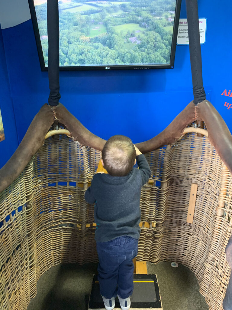 child flying a hot air balloon simlulator at the Bucks County Children's Museum