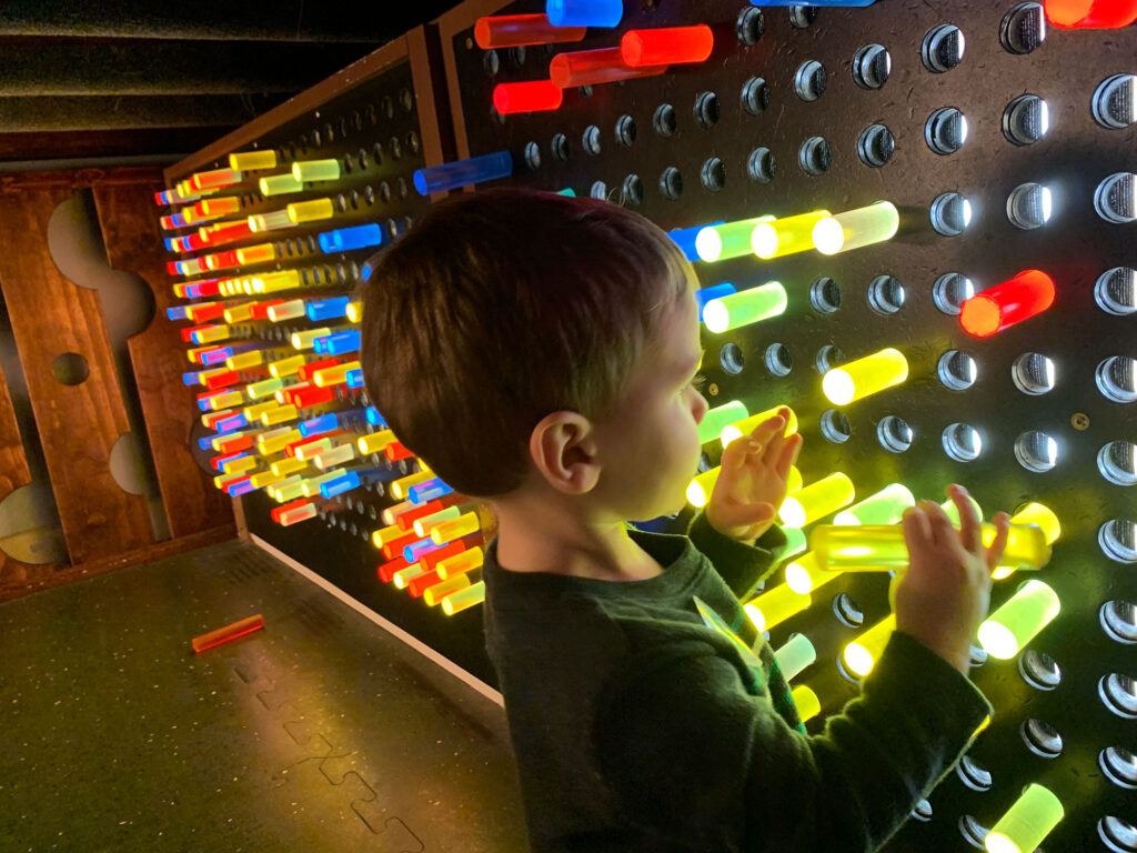 child playing with a Lite Brite wall at the Bucks County Children's Museum