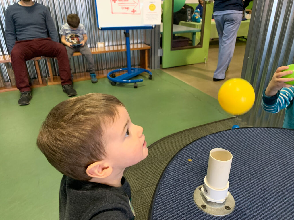 child watching a ball float above a PVC pipe at the Bucks County Children's Museum