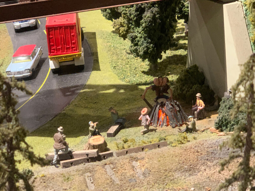 scale model of a hobo encampment under a bridge with a figure of a three-headed troll