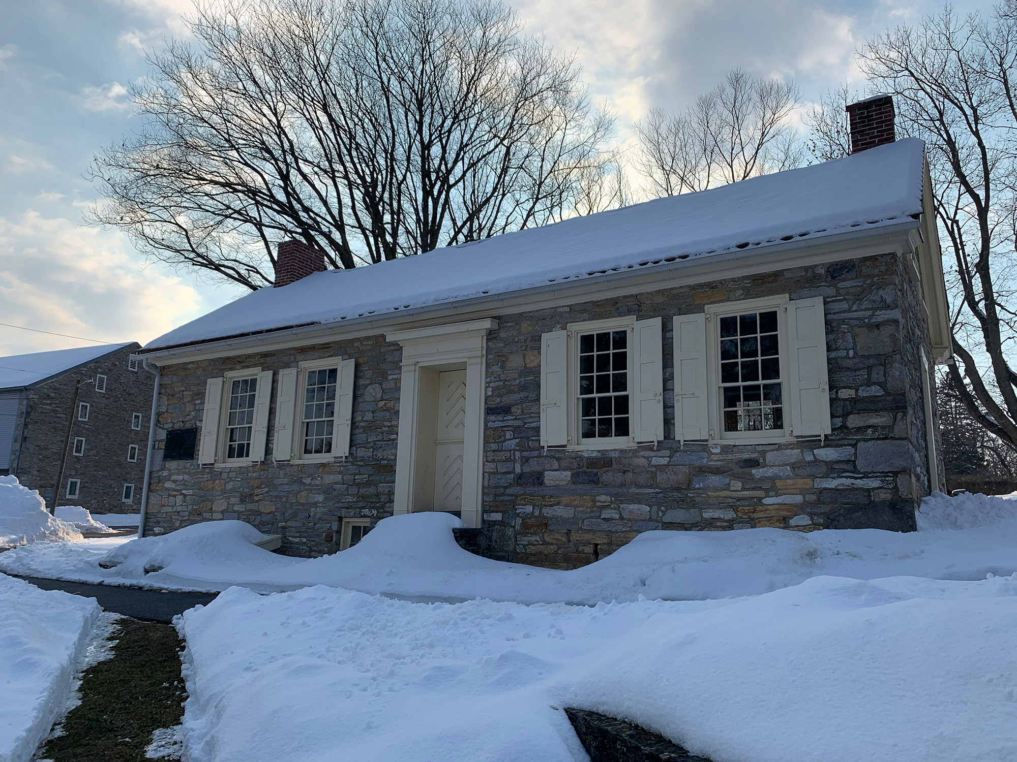 snow covers the roof of an 18th century stone building at the Conrad Weiser Homestead