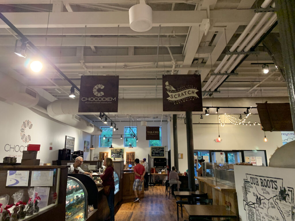 Signs for Chocodiem and Scratch hang above their respective stands at Easton Public Market