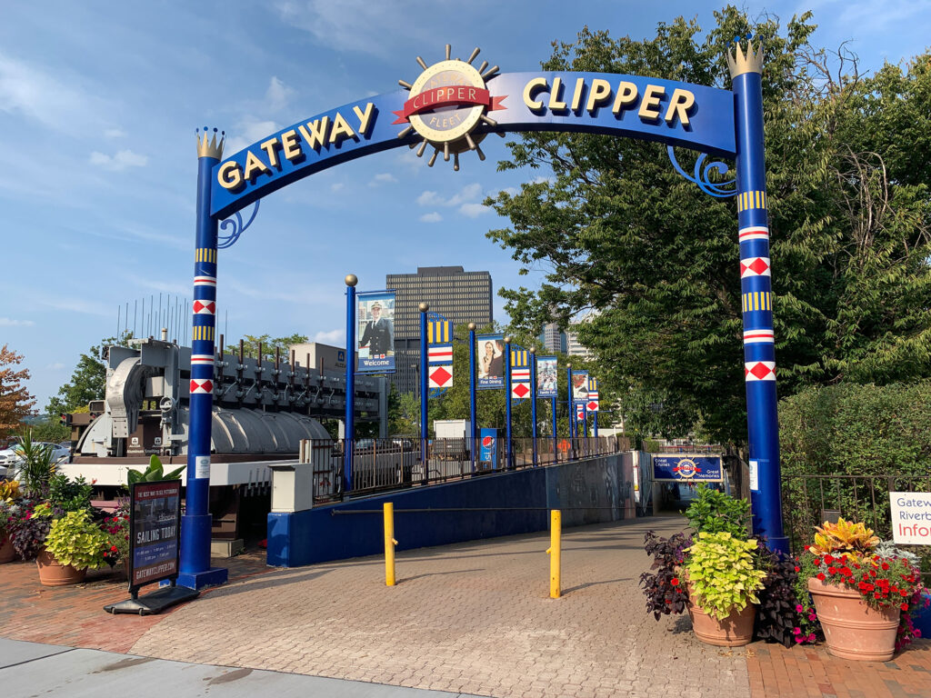 Blue sign with white letters reading "Gateway Clipper" above a walkway leading to the Pittsburgh waterfront