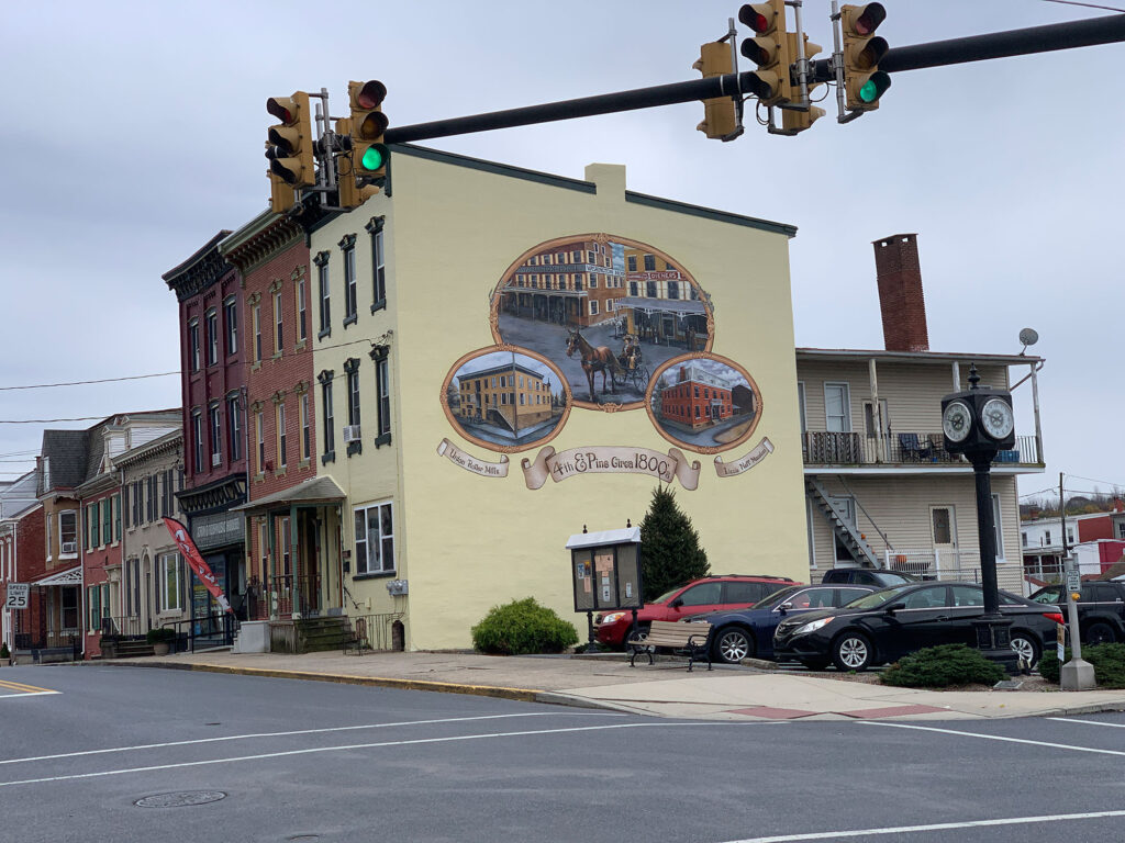 mural on side of a large building depicting the history of Hamburg PA