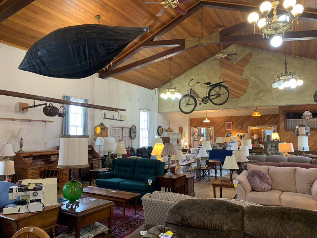 a boat and a bicycle hang from the ceiling about furniture for sale at Necessities in Hamburg, PA