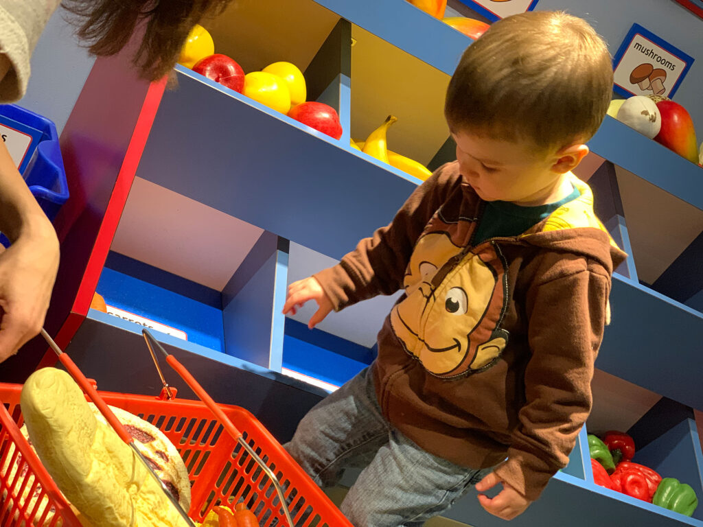 child playing with a grocery set at the HAnds-On House in Lancaster, PA