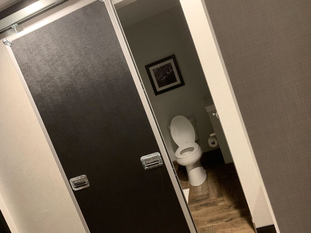 Bathroom inside Hotel Rock Lititz with the top of an equipment box used as a door