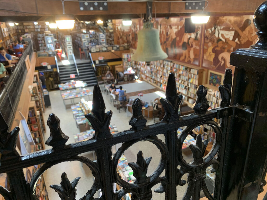 View through a wrought iron railing on the second floor of the Midtown Scholar Bookstore looking out over the main lobby area