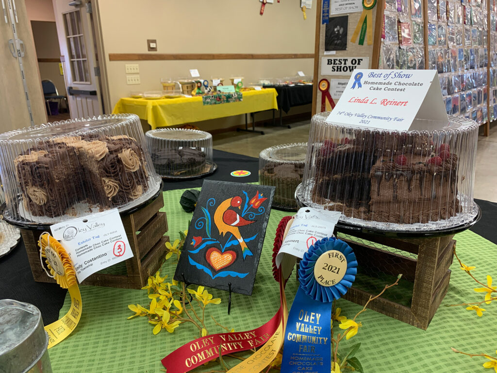 various baked goods in plastic clamshells wtih blue ribbons denoting winners
