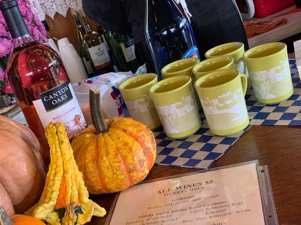 glasses of wine next to green cups sitting on a table with gourds