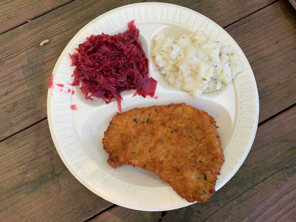 plate with pork schnitzel, red cabbage and potatoes