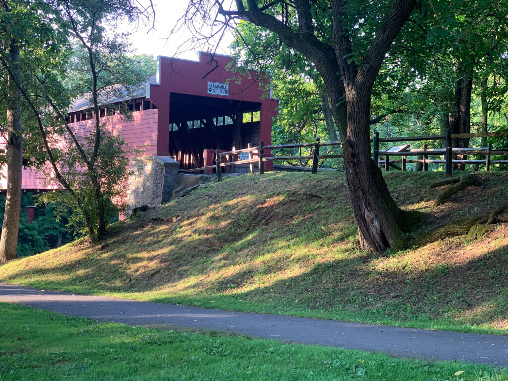 Red covered bridge behind a bike path