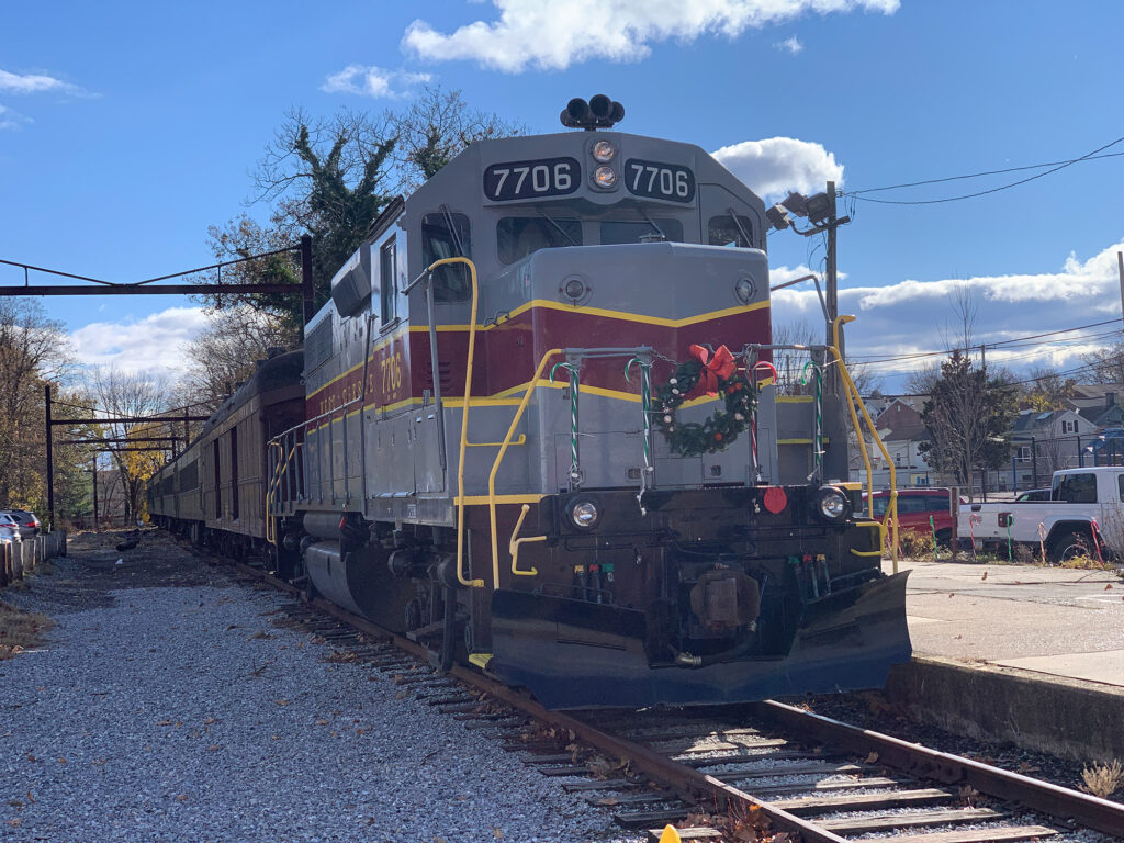 Gray diesel engine with maroon stripe and a Christmas wreath on the front