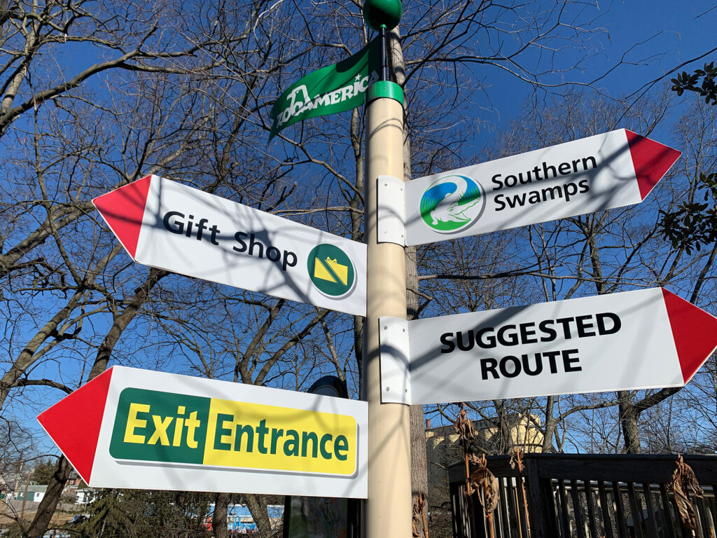 Signpost with four directional signs pointed at different areas within ZooAmerica