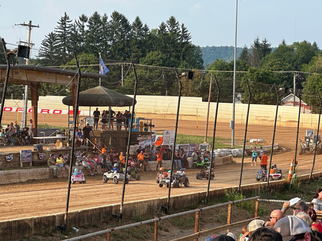 kids driving Power Wheels on a dirt track in a fun version of a demolition derby