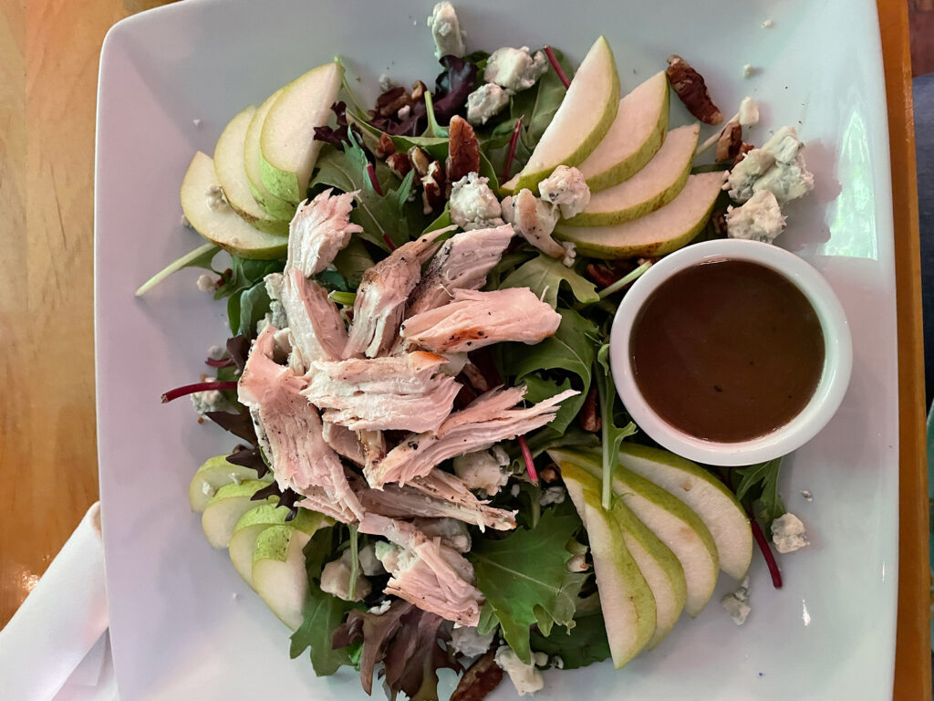 white plate with a salad topped with pears and chicken from Cafe Arielle in Jim Thorpe, PA