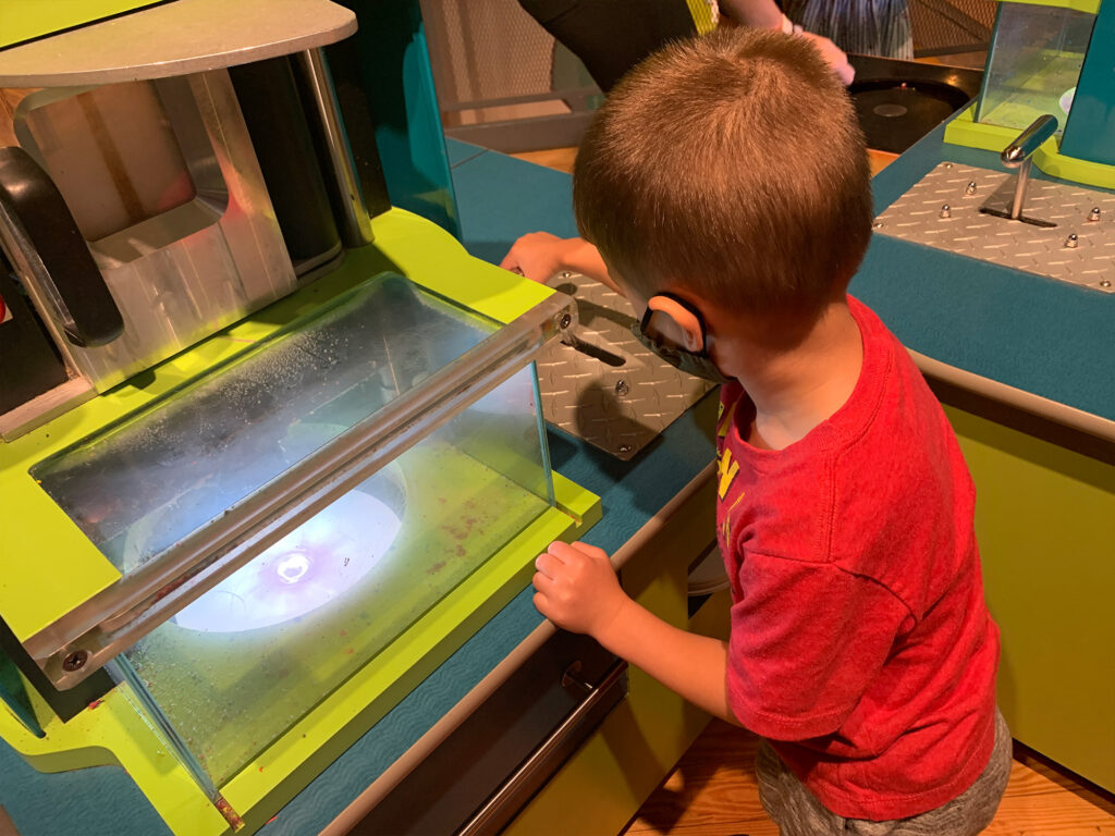 child at a drip art machine at Crayola Experience