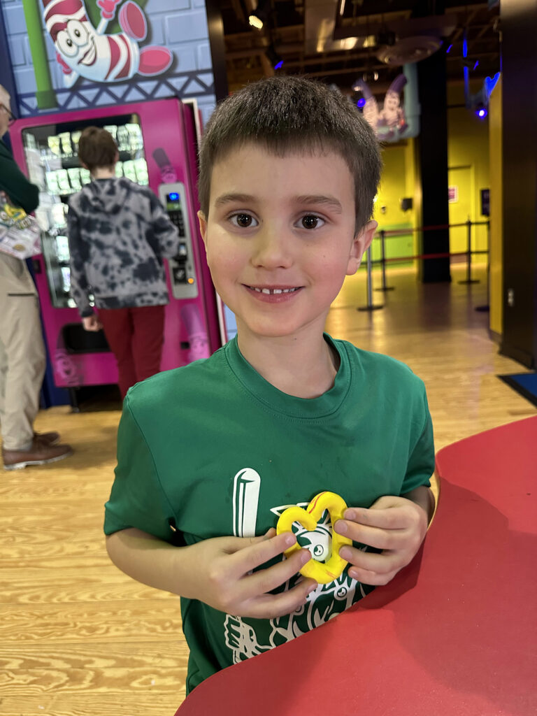 child holding a heart made out of yellow modeling clay