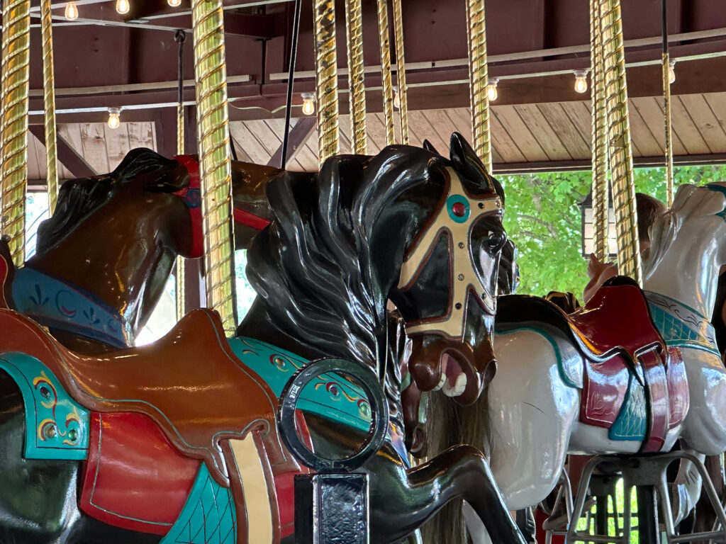 close-up picture of carousel horse painted black with teal accents