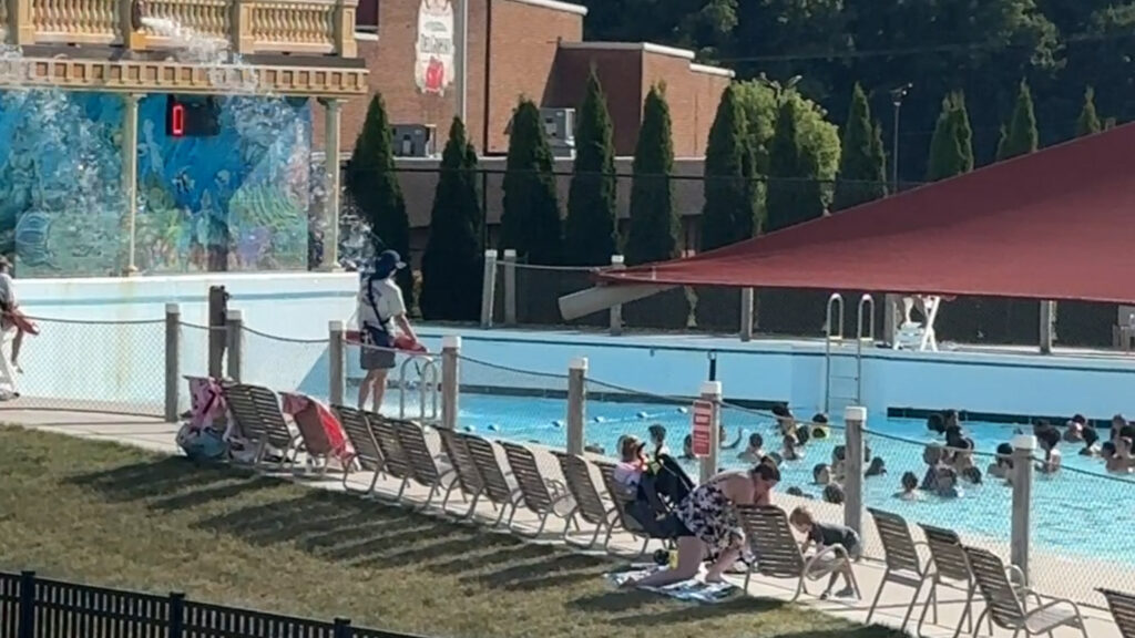 a crowd of people stand in a wave pool waiting for the next wave