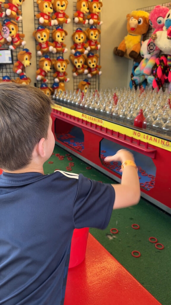 boy tossing rings at glass bottles at Delgrosso's Amuseument Park