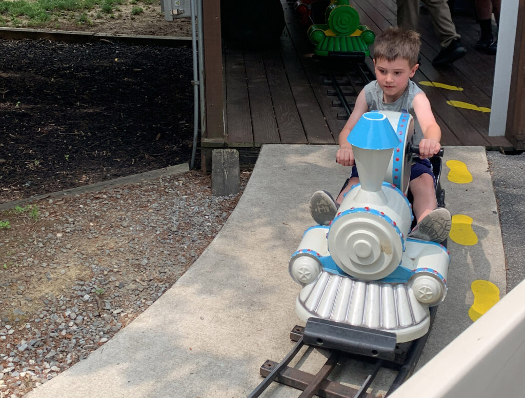 child riding a hand-crank powered train at Dutch Wonderland