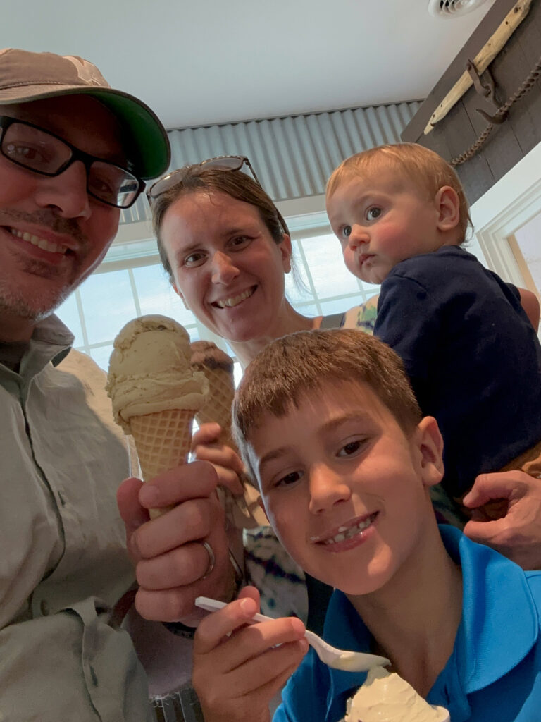 selfie of a man and woman with two young boys holding ice cream cones