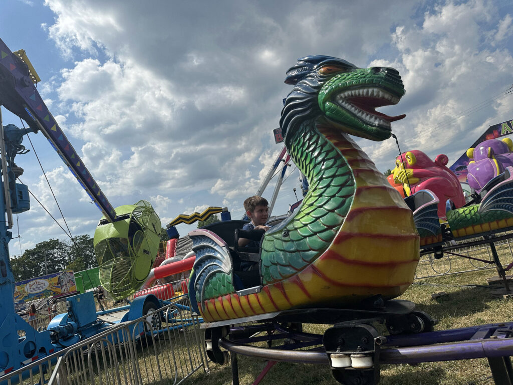 child riding on a dragon-shaped roller coaster at the Lebanon Fair