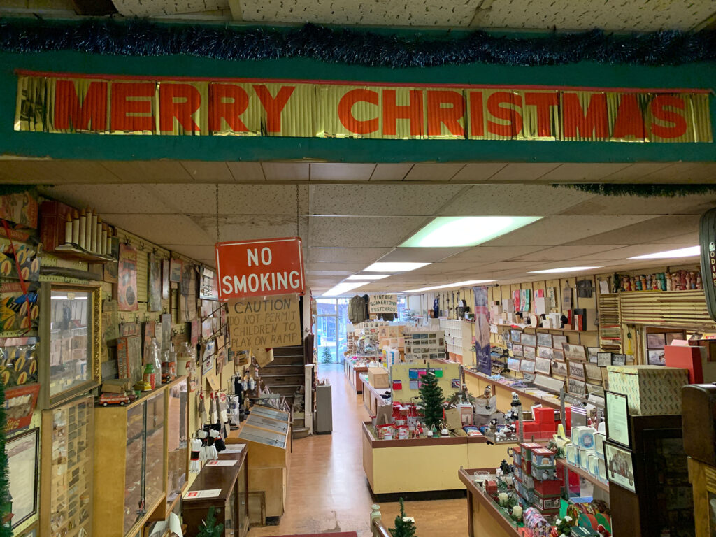 "Merry Christmas" sign above a archway looking into the main shopping area of Sine's 5 & 10