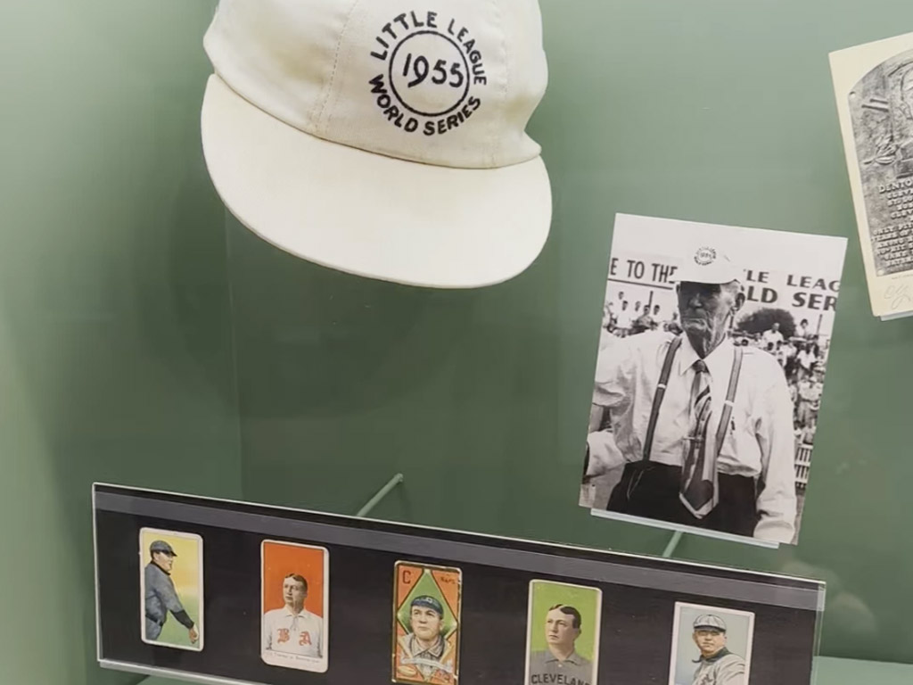 a hat, photo and baseball cards of Cy Young on display at the Little League Museum