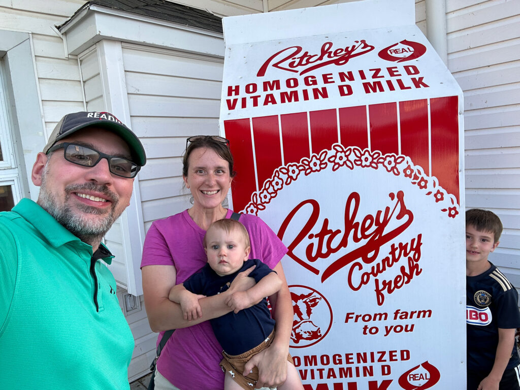 Family of four poses with a giant milk carton at Ritchey's Dairy