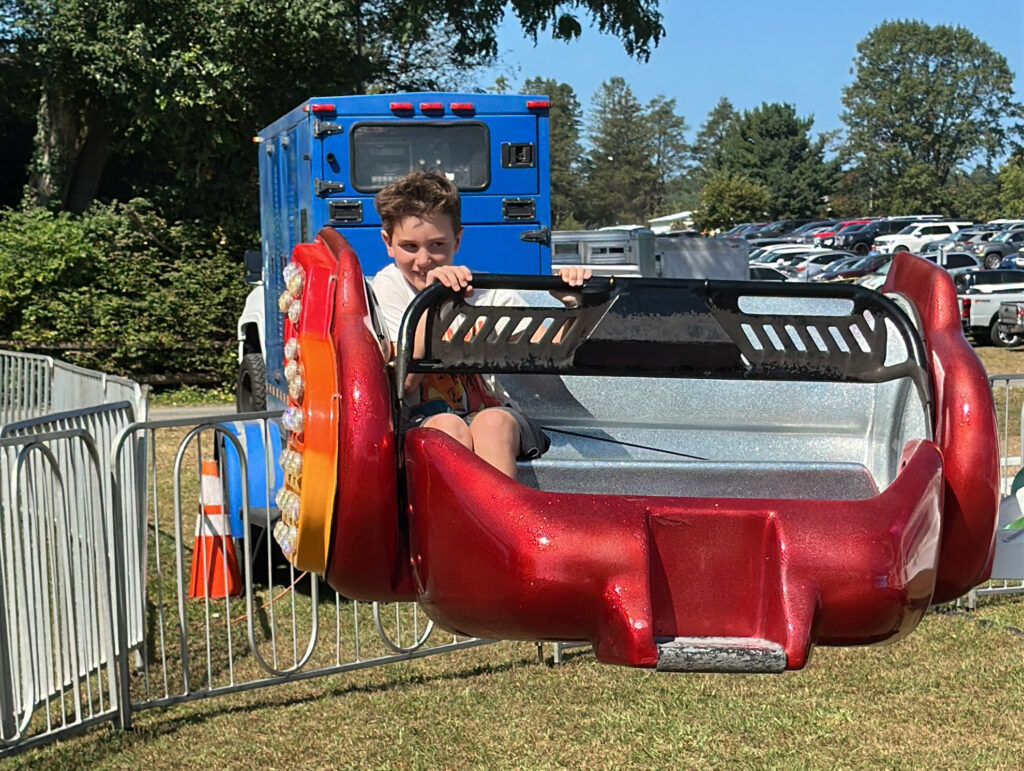 young boy rup against the side of a car on a scrambler ride
