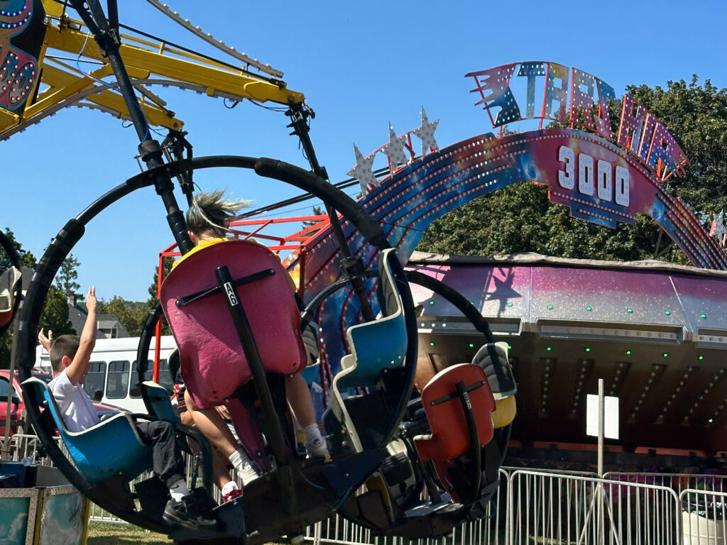carnival ride with four seats suspended from an arm in a circular spinner