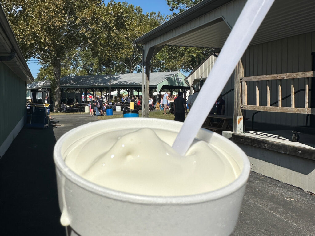 close-up of a vanilla milkshake in a white styrofoam cup with a white spoon sticking out