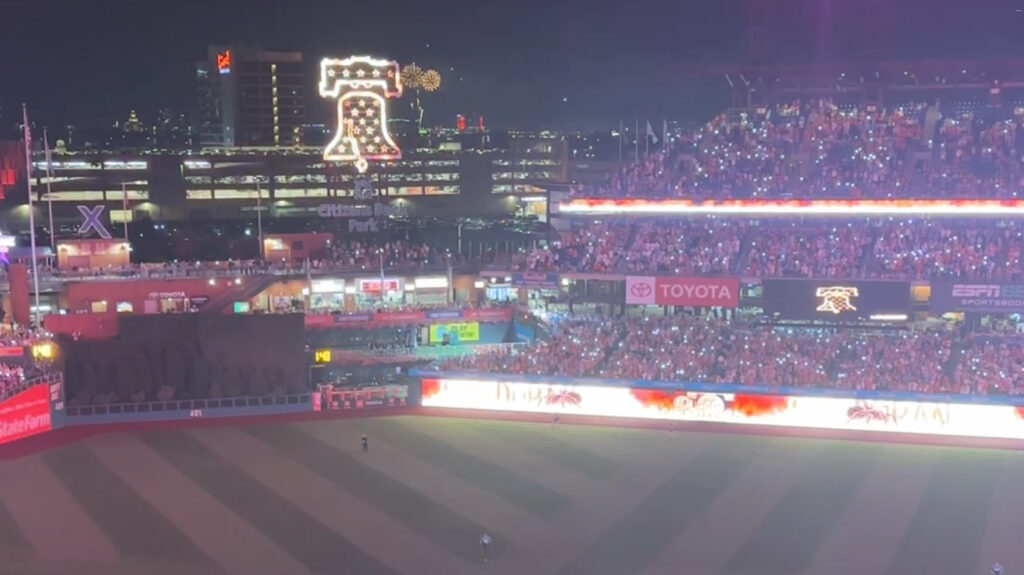 Lights out at a baseball stadium with LED boards lit up with fire and a spider