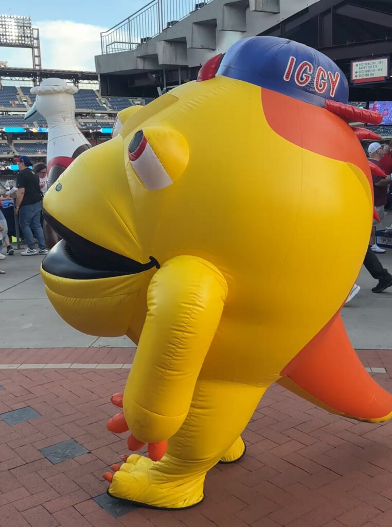 Yellow inflatable mascot with a blue hat and orange tail