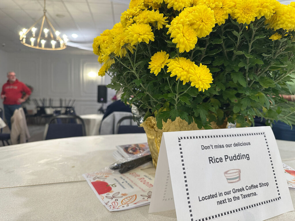 table covered with a white tablecloth with a yellow floral centerpiece from the Greek Food Bazaar in Reading, PA.