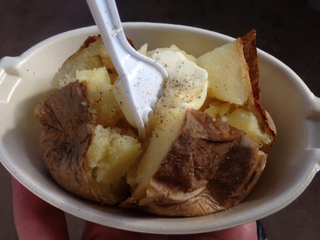 baked potato with a white plastic fork sticking in the middle