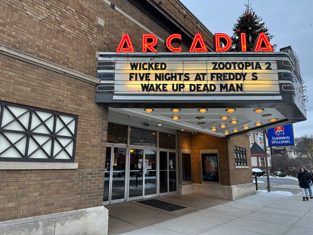 Facade of a brick building with old-time movie theater marquee that reads "ARCADIA"