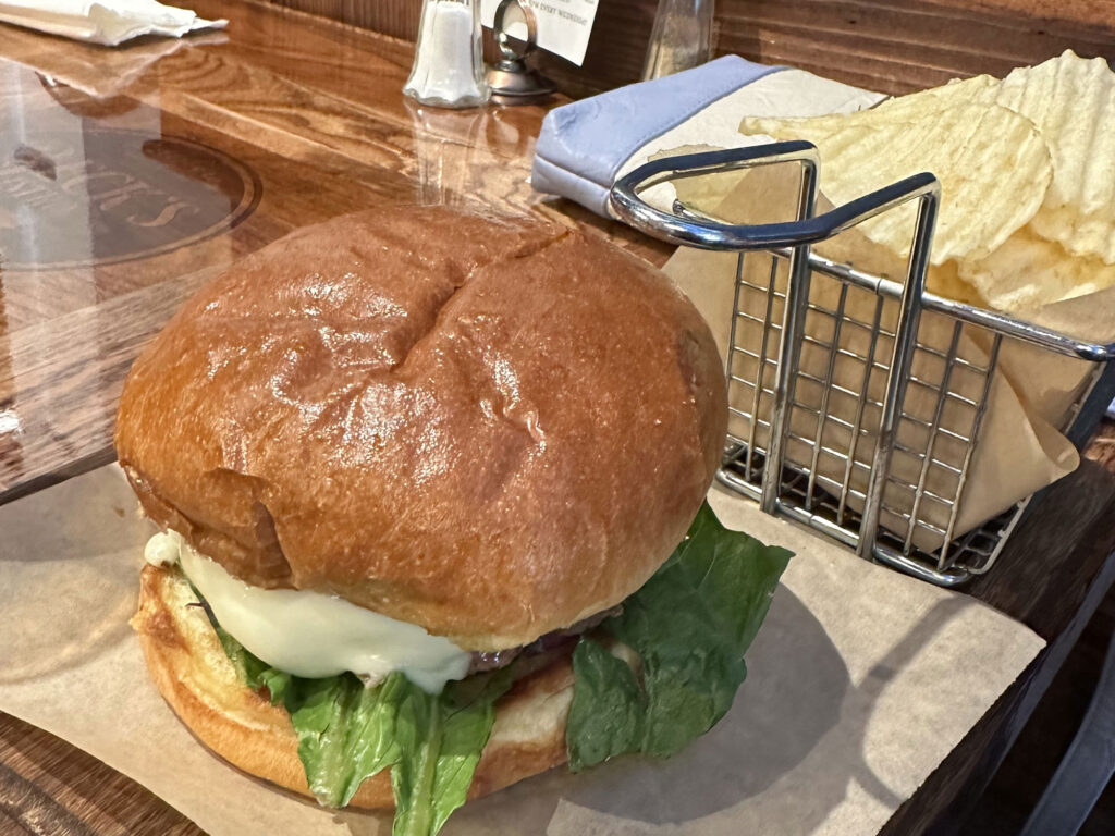 burger with lettuce and cheese next to a basket of chips from Beck's Bistro in Wellsboro