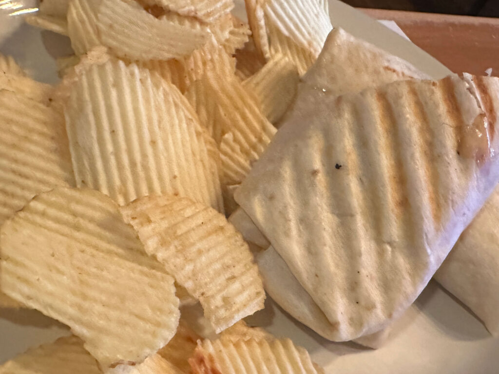 plate with ruffle chips on the left and a pressed wrap on the right