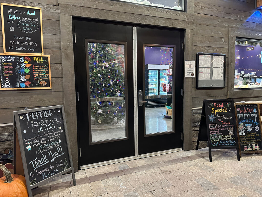 front door at Hume's Blooms in Wellsboro with black sandwich boards on either side with the day's specials