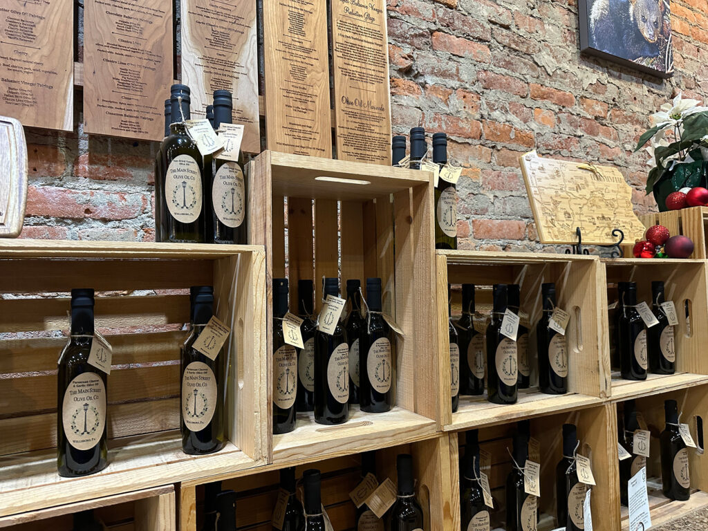 Bottles of olive oil and vinegar on wooden shelves from Main Street Olive Oil in Wellsboro, PA